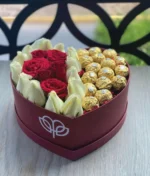 arreglo en forma de corazón de rosas rojas y blancas con ferreros