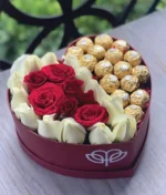 arreglo en forma de corazón de rosas rojas y blancas con ferreros