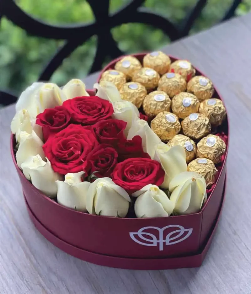 arreglo en forma de corazón de rosas rojas y blancas con ferreros