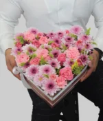 hombre con arreglo en forma de corazón con flores rosas