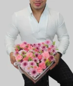 hombre con arreglo en forma de corazón con flores rosas