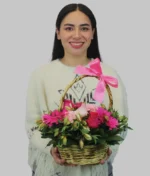 mujer con canasta de flores rosas