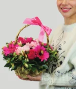 mujer con canasta de flores rosas