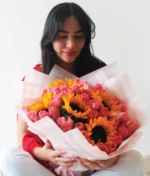 mujer con ramo de girasoles y rosas