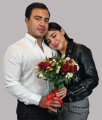 pareja con jarrón de rosas rojas