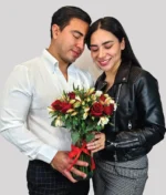 pareja con jarrón de rosas rojas