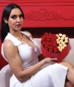 mujer con arreglo de corazón con rosas rojas y ferreros