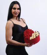 mujer con arreglo de corazón con rosas rojas y ferreros