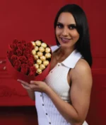 mujer con arreglo de corazón con rosas rojas y ferreros