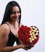 mujer con arreglo de corazón con rosas rojas y ferreros